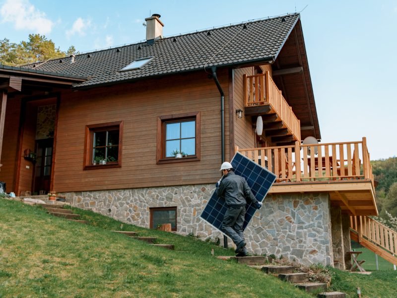 A man worker carrying solar panel for installing solar modul system on house.